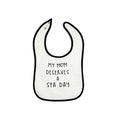 White baby bib with black trim and the phrase "My mom deserves a spa day" printed in simple black lettering, featuring the product name Mom Deserves A Spa Day Baby Bib | Lucky Owl.